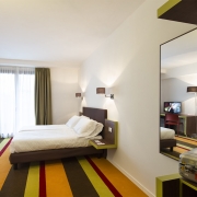colourful hotel carpet and white bed
