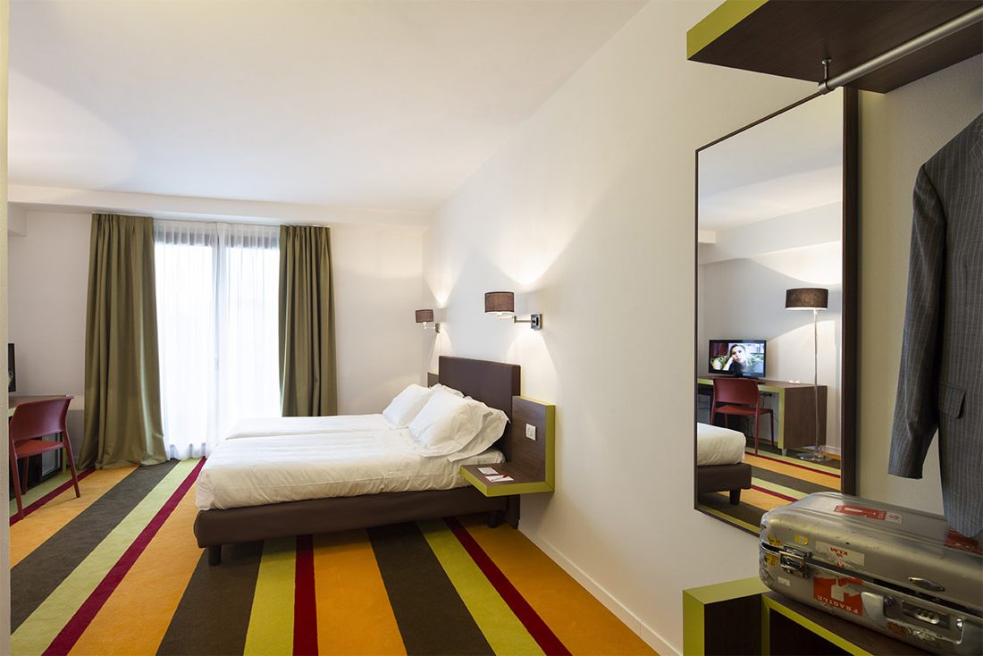 colourful hotel carpet and white bed