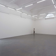 man standing in a large gallery room