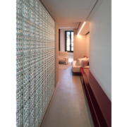 Palazzo Rhinoceros corridor with bespoke furniture in red lacquered wood and glass bricks wall