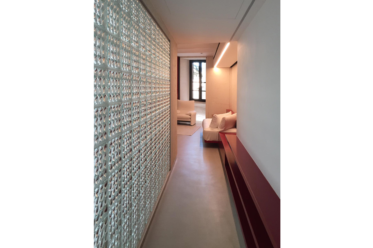 Palazzo Rhinoceros corridor with bespoke furniture in red lacquered wood and glass bricks wall