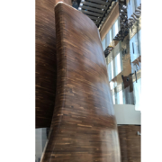 Detail of the double-curved American walnut walls that define the Vertigo restaurant inside the Banyan Tree Doha hotel