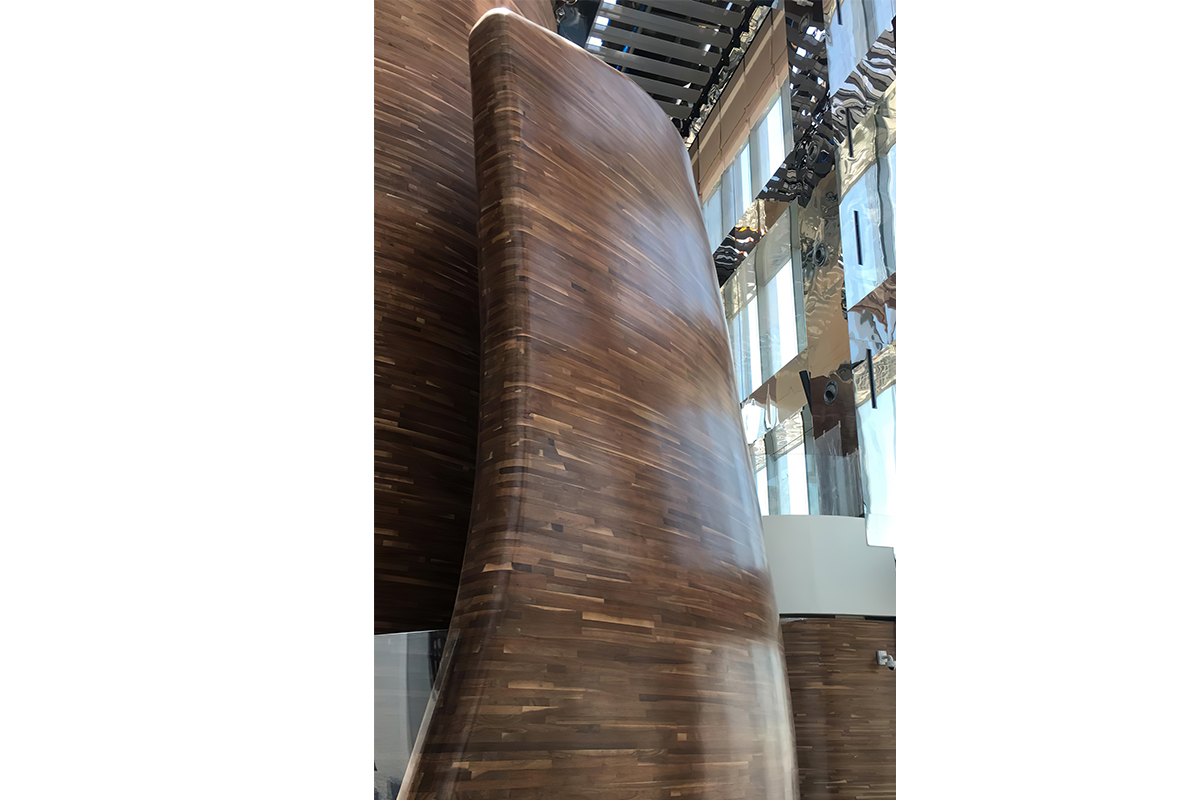Detail of the double-curved American walnut walls that define the Vertigo restaurant inside the Banyan Tree Doha hotel