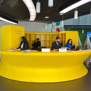 curving yellow reception desk, receptionists